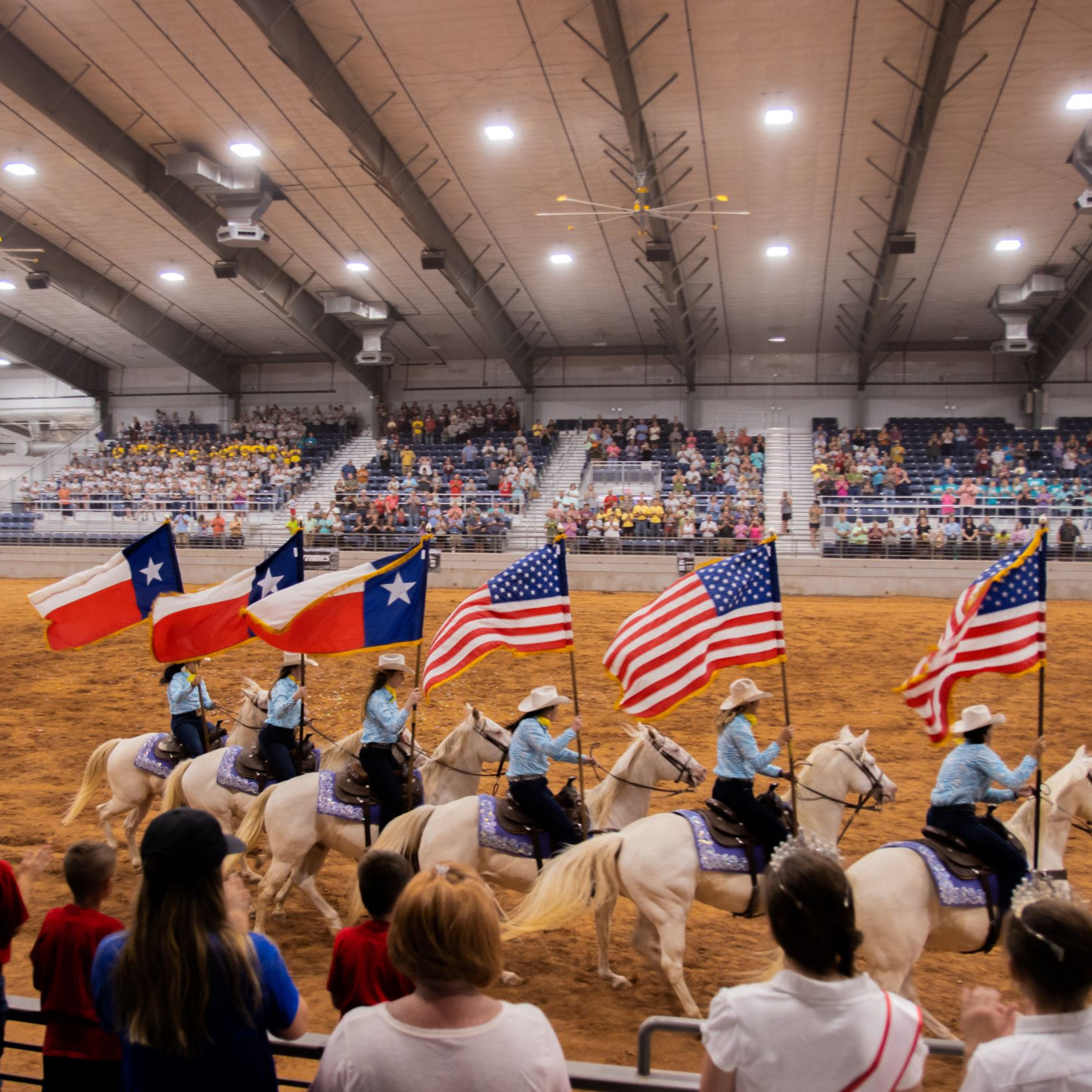 Taylor county expo center - riders on horses carrying US and Texas Flags